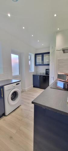 Una cocina con lavadora y secadora en una habitación. en Luxury 2 Bedroom Home Dagenham, en Dagenham