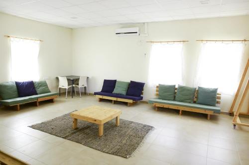 a waiting room with blue couches and a table at Neot Semadar Eco Lodge in Naẖal Ya‘alon