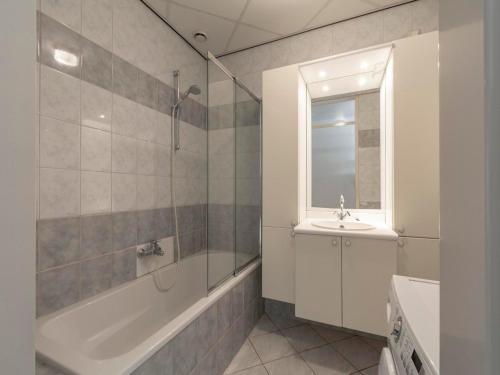 Un baño con bañera, lavabo y ducha. en Beachside Escape w Terrace, en Julianadorp