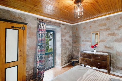 a bedroom with a bed and a dresser and a window at Quinta das Queimadas in Nordeste