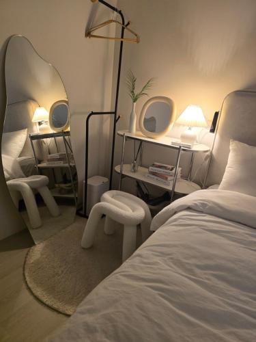 a bedroom with a bed with a mirror and a chair at 심, 쉼 Stay Hwangridan-gil 침대4개 8인숙소 in Gyeongju