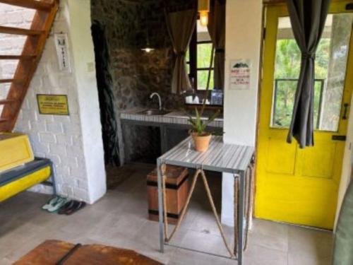 a kitchen with a sink and a yellow door at Galunggung Basecamp Villa 