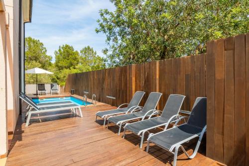 a deck with chairs and a swimming pool at Tomymar in Cala Ratjada