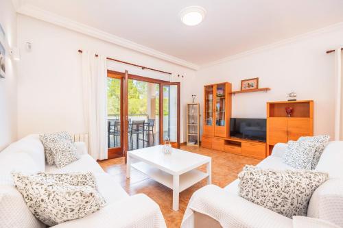a living room with two white couches and a tv at Tomymar in Cala Ratjada