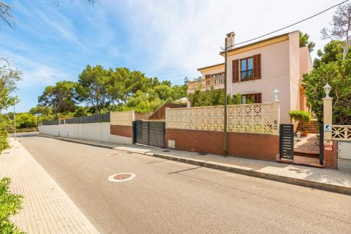 a house with a fence on the side of a road at Tomymar in Cala Ratjada