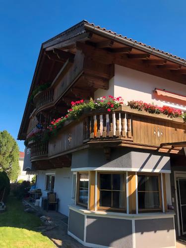 a building with a balcony with flowers on it at Wia Dahoam Appartement in Völs
