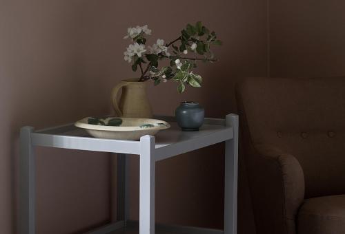 a white table with a vase and flowers on it at Stay North - Matri House in Mathildedal