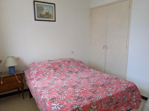 une chambre avec un lit avec une couverture rouge dans l'établissement T2 Climatisé, 2 Cours, Proche Plage, Parking Privé, 5 Pers., Animaux Acceptés - FR-1-797-58, à Port-la-Nouvelle