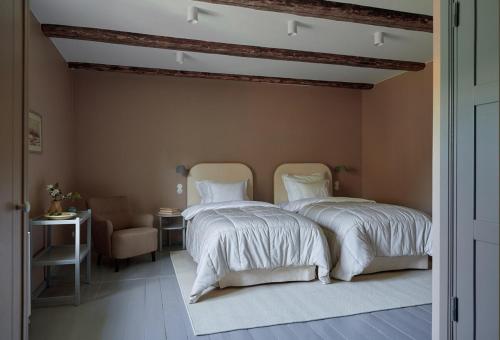 a bedroom with two beds and a chair at Stay North - Matri House in Mathildedal