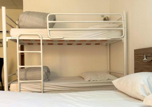 a room with two bunk beds and a bed at Hôtel Le Carnon in Carnon-Plage