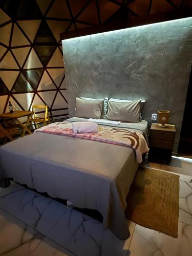 a bedroom with a large bed in a room at Pousada Domos Serra do Sol in Monte Verde