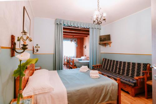 a bedroom with a bed and a couch at Hotel Napoleon in Montjovet
