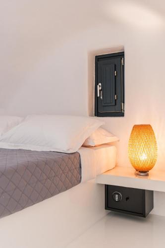 a bedroom with a bed and a lamp on a shelf at Alba Caverns in Fira
