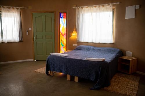 a bedroom with a bed and a stained glass window at Neot Semadar Eco Lodge in Naẖal Ya‘alon