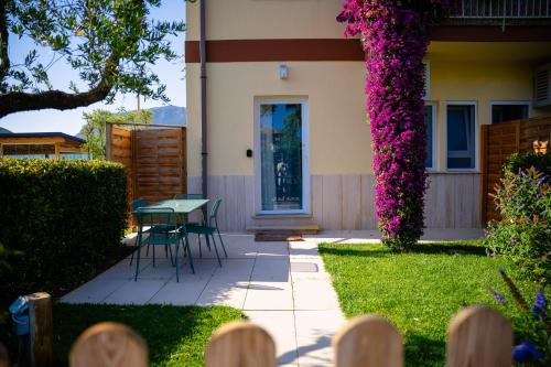 a patio with a table and purple flowers at Olivia La Casa sul fiume in Terracina