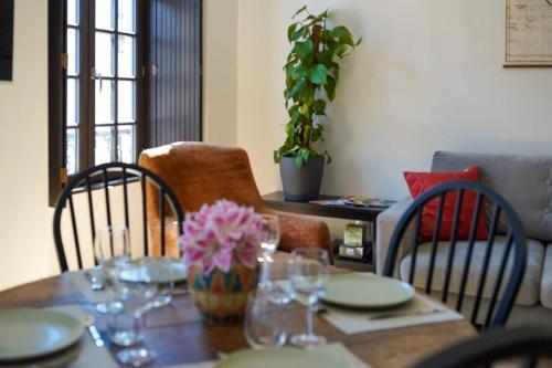 - une table à manger avec des verres à vin et des fleurs dans l'établissement T3 cœur de ville avec climatisation, à Brive-la-Gaillarde