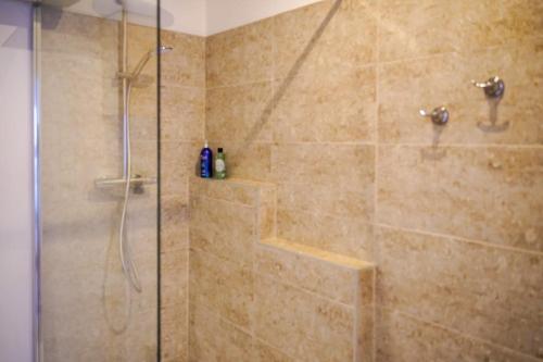 un bagno con doccia con porta in vetro di T3 cœur de ville avec climatisation a Brive-la-Gaillarde