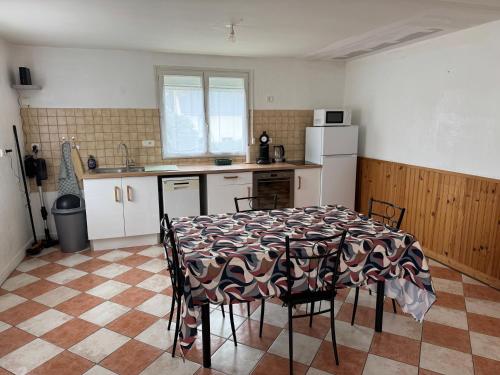 une cuisine avec une table et des chaises dans une pièce dans l'établissement La petite Varenne 28, à La Chapelle-du-Noyer