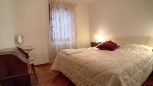 una camera da letto con un letto bianco e una finestra di Il Pianello di Badia Prataglia a Badia Prataglia
