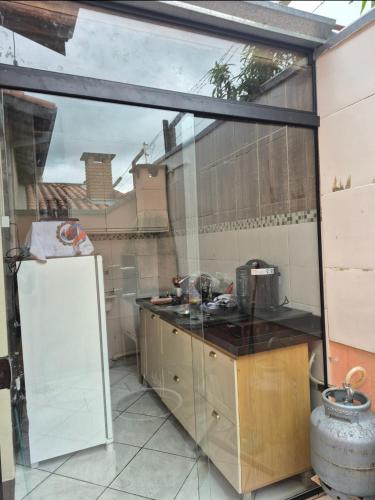 a kitchen with a large glass window and a sink at Casa Studio 1 Quarto in São José dos Campos