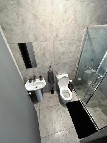 ein Badezimmer mit Toilette, Waschbecken und Dusche in der Unterkunft Sunbird self-catering 3 in Windhoek