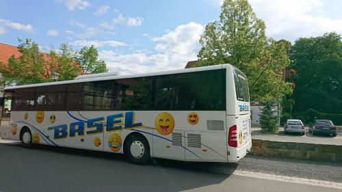 a white bus parked on the side of the street at Landgasthof Hummel in Ebensfeld