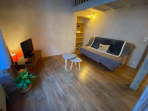 un petit salon avec un lit et une table dans l'établissement Joli appartement avec charme, à Cahors