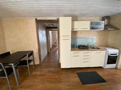 une cuisine avec des armoires blanches et une table et une salle à manger dans l'établissement Joli appartement avec charme, à Cahors