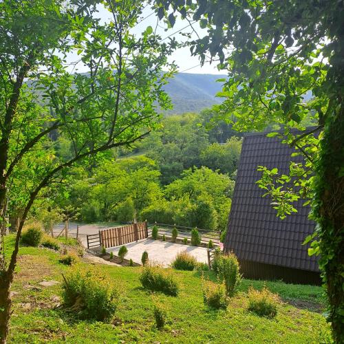 a park with a bench and a view of the mountains at Green Paradise Martvili Cottege in Martvili
