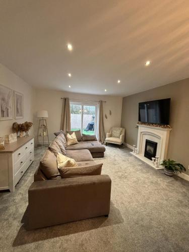 a living room with a couch and a fireplace at Central Lakes Staycation in Penrith