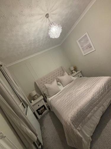 a bedroom with a bed and a chandelier at Central Lakes Staycation in Penrith