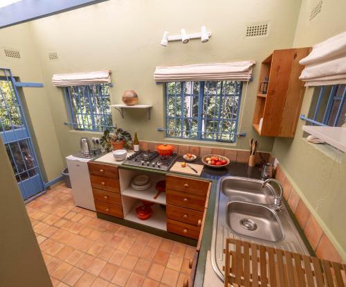 eine kleine Küche mit Spüle und Herd in der Unterkunft Forest Haven in Harare