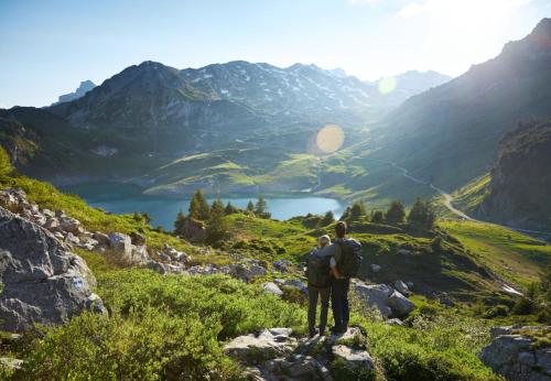 two people standing on a mountain overlooking a lake at Hölderle Damüls in Damuls