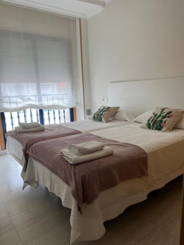 sypialnia z dużym łóżkiem i ręcznikami na nim w obiekcie APARTAMENTO LA PERLA w mieście Portonovo
