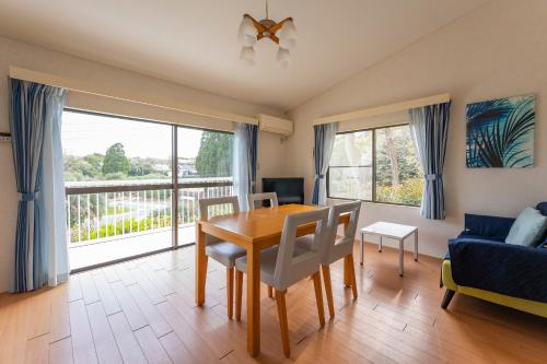 a living room with a dining room table and a couch at Le Nessa Jyogasaki in Ito