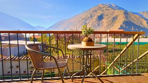 a table and chair on a balcony with a mountain at Hotel and Country House Valle Sagrado de los Incas in Huaran