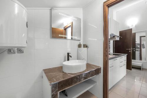 a white bathroom with a sink and a mirror at Holiday home Vodice in Vodice