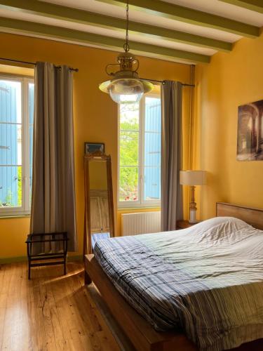 une chambre avec un lit et une grande fenêtre dans l'établissement Villa Meunière, à Le Bourdet