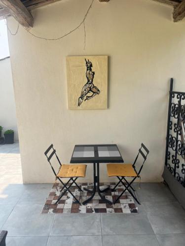 une table avec deux chaises et une photo d'une fugue dans l'établissement CHAMBRE d'HOTES POUR 2 PERSONNES, à Peymeinade