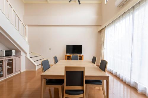 a dining room with a table and chairs at Le Nessa Jyogasaki in Ito