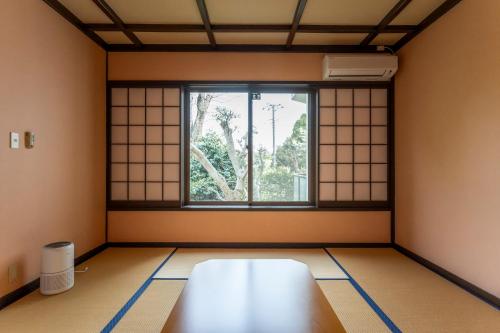 a room with a table and a window at Le Nessa Jyogasaki in Ito