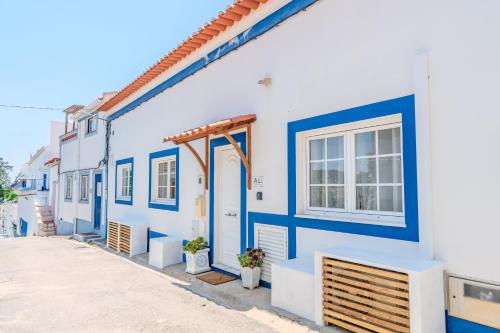 a blue and white building with a blue door at Casa dos Rosas in Melides