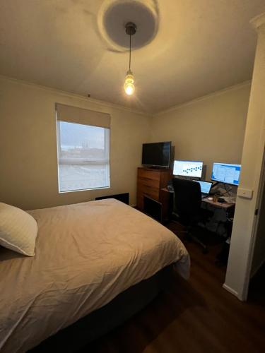 a bedroom with a bed and a desk with two computers at The Ryrie Loft in Geelong