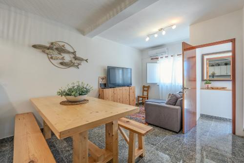 a living room with a wooden table and a couch at Casa dos Rosas in Melides