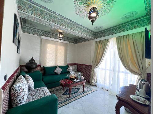 a living room with a green couch and a table at Menzeh Zalagh 2Boutique Hôtel & Sky in Fès