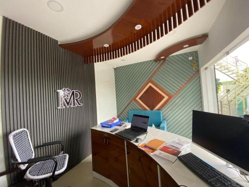 an office with a desk with a laptop computer on it at Maran Residency in Kovilpatti