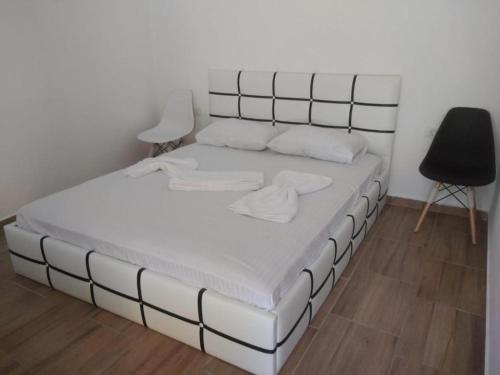 a large white bed in a room with a black chair at The sweet house! in Vama Veche