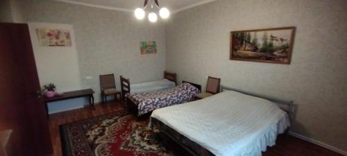 a bedroom with two beds and a table and chairs at Guest House Ed&Er in Argavand