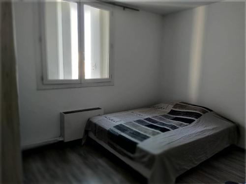 une chambre blanche avec un lit et une fenêtre dans l'établissement appartement le cézanne, à Toulon