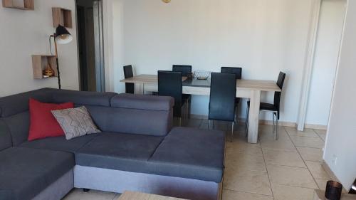 un salon avec un canapé et une table avec des chaises dans l'établissement appartement le cézanne, à Toulon